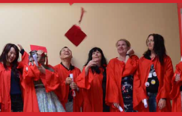 graduates of scarlet alliance education program in red robes throw red hats
